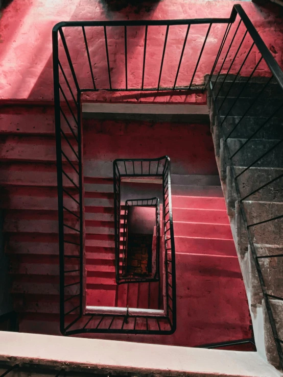 a spiral staircase going up the side of a building, inspired by Hubert Robert, pexels contest winner, modernism, red room, inside an old apartment, payne's grey and venetian red, pink concrete