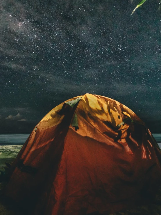 a red tent sitting on top of a sandy beach, poster art, by Adam Marczyński, trending on unsplash, dark starry sky, closeup portrait shot, ☁🌪🌙👩🏾, extreme panoramic