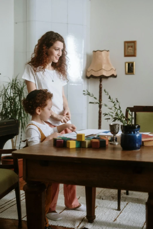 a woman and a child sitting at a table, pexels contest winner, busy room, low quality photo, ad image