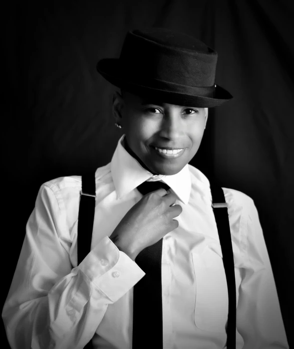 a black and white photo of a man wearing a hat, an album cover, inspired by Randy Vargas, harlem renaissance, beautiful androgynous girl, professional photo-n 3, black tie, while smiling for a photograph