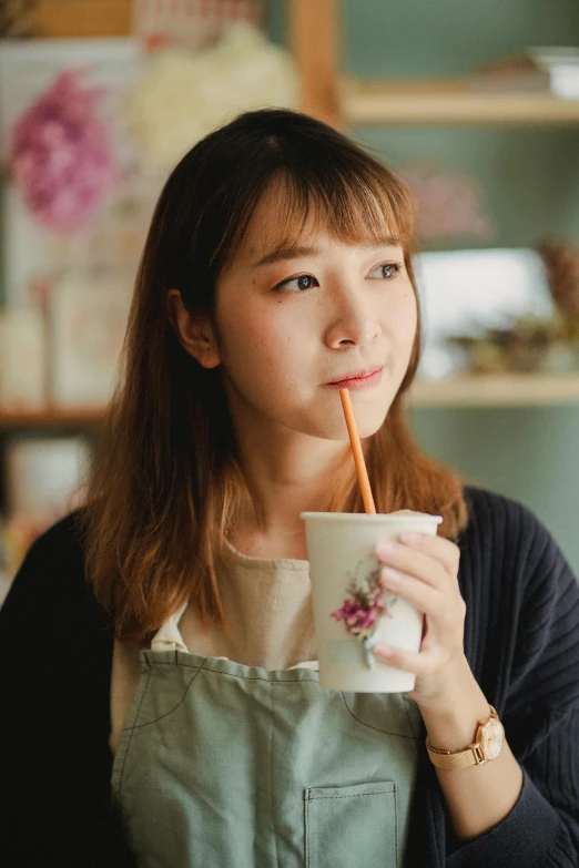 a woman drinking out of a cup with a straw, a picture, inspired by Kim Jeong-hui, trending on pexels, hyperrealism, looking away from camera, young adorable korean face, professional profile picture, wearing casual clothing