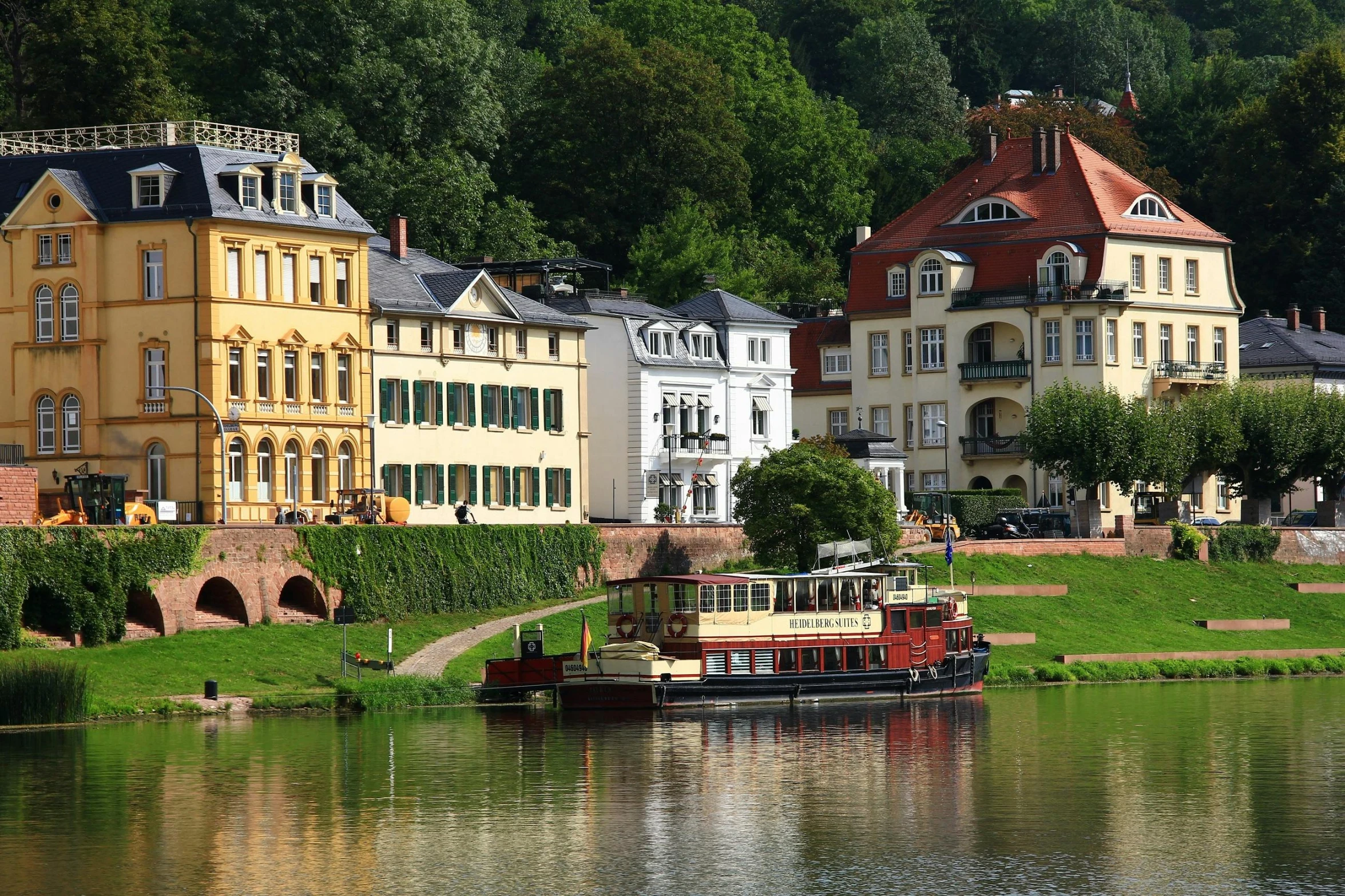 a boat sitting on top of a river next to a lush green hillside, german romanticism, round buildings in background, avatar image, slide show