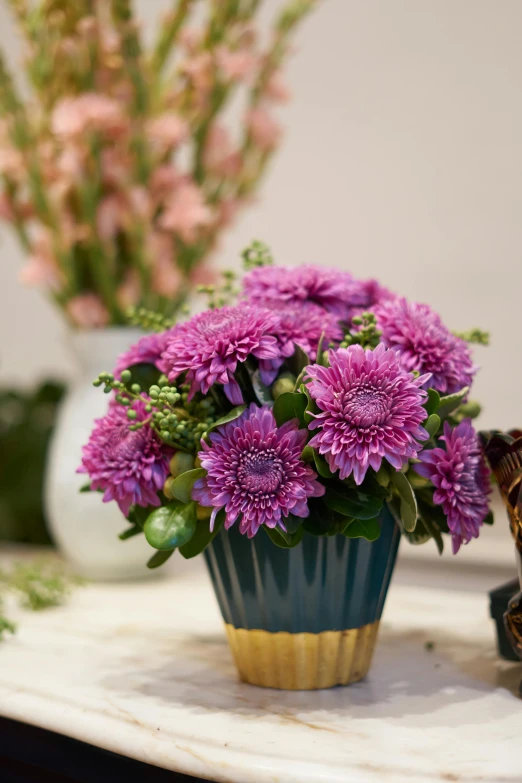 a vase filled with purple flowers sitting on top of a table, inspired by Margareta Sterian, baroque, chrysanthemum, purple mist, fan favorite, vibrant color with gold speckles