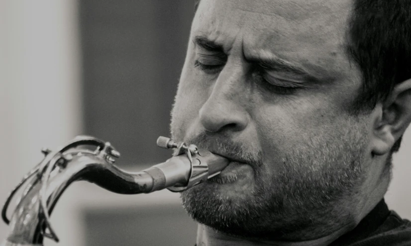 a black and white photo of a man playing a saxophone, inspired by Russell Drysdale, pexels contest winner, photorealism, a hookah smoking caterpillar, clear julian lage face, middle close up, taken in the late 2000s