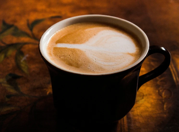 a close up of a cup of coffee on a table, by Adam Chmielowski, renaissance, fan favorite, milk, profile image, hot cocoa drink