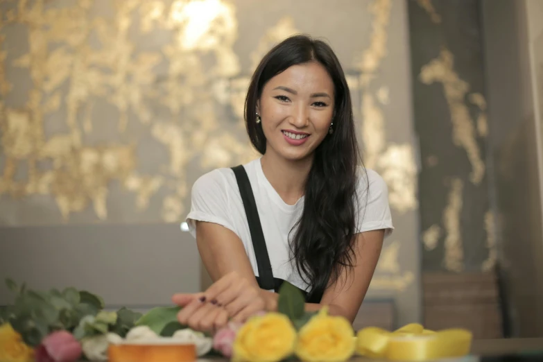 a woman sitting at a table with a plate of food, flowers in background, darren quach, portrait image, gemma chen