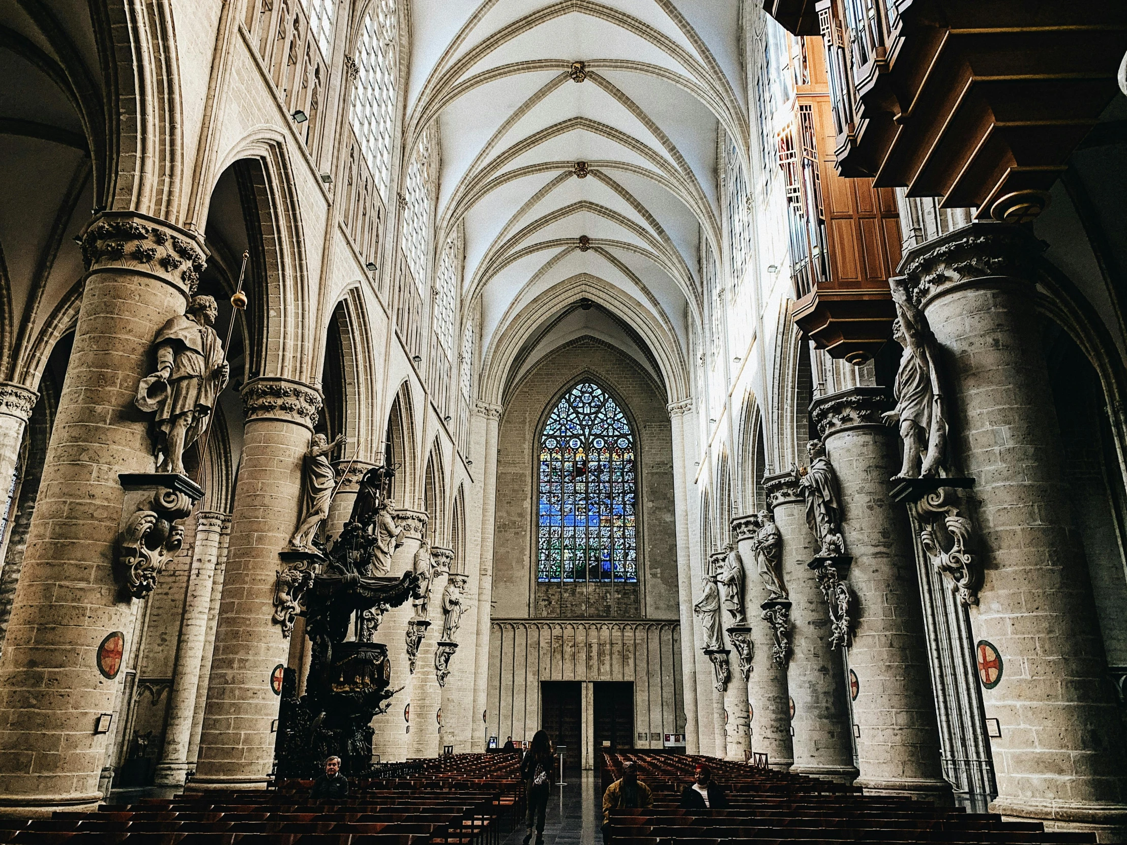 the inside of a church with pews and a stained glass window, inspired by Barthélemy d'Eyck, pexels contest winner, behind her a gothic cathedral, thumbnail, giant columns, brussels