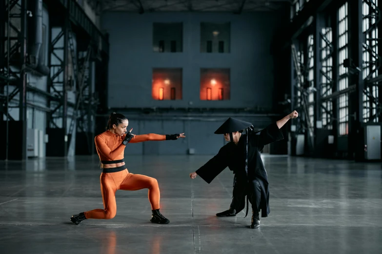 a couple of people standing on top of a cement floor, inspired by Kanō Hōgai, pexels contest winner, antipodeans, gandalf fighting darth vader, in orange clothes) fight, wearing a black catsuit, futuristic fashion show