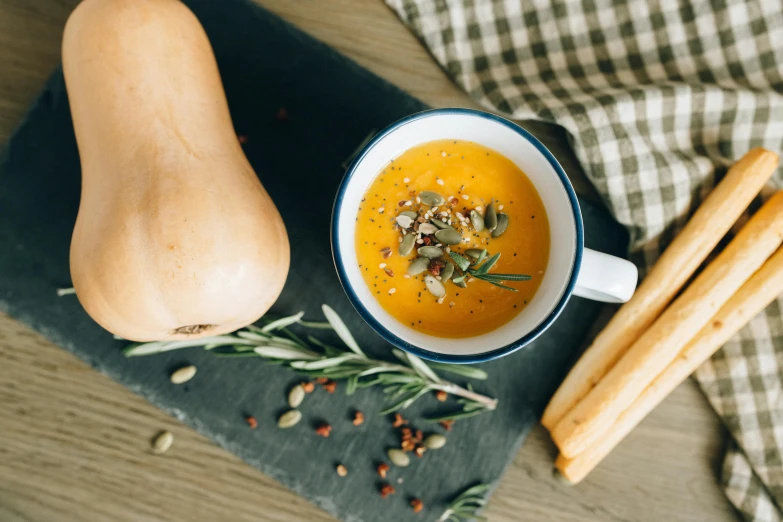 a bowl of soup sitting on top of a cutting board, by Emma Andijewska, pexels contest winner, pumpkin, square, high-resolution, breakfast