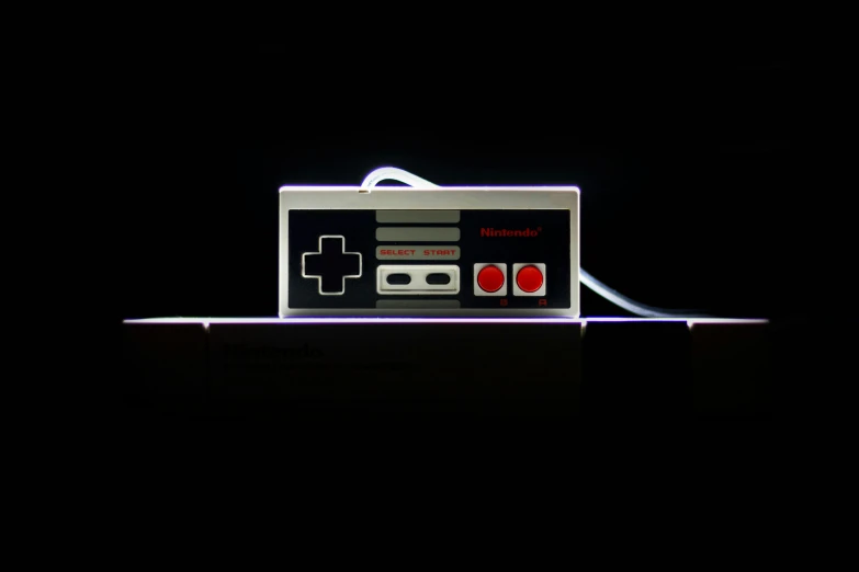 a video game controller sitting on top of a table, inspired by Mario Comensoli, light box, in front of a black background, electric wallpaper, dramatic lighting - n 9