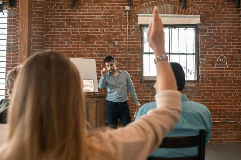 a man giving a presentation to a group of people, pexels contest winner, renaissance, sassy pose, 9 9 designs, back towards camera, raised hand