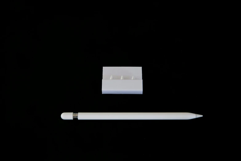a white pen sitting next to a piece of paper, inspired by Robert Mapplethorpe, minimalism, 3 d print, tiny smokes from buildings, 3 - piece, apple design