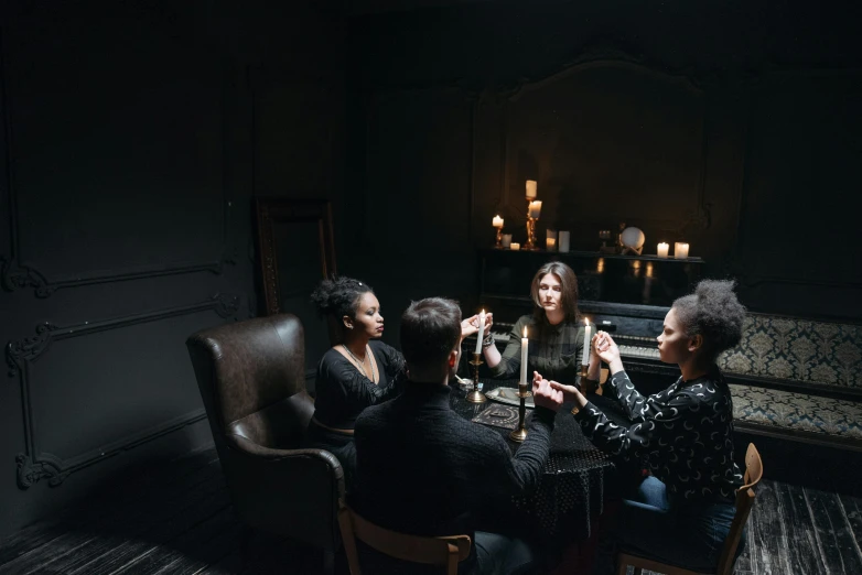 a group of people sitting around a table, by Elsa Bleda, pexels contest winner, renaissance, dracula fangs! haunted house, holding a candle, an escape room in a small, sitting in a lounge