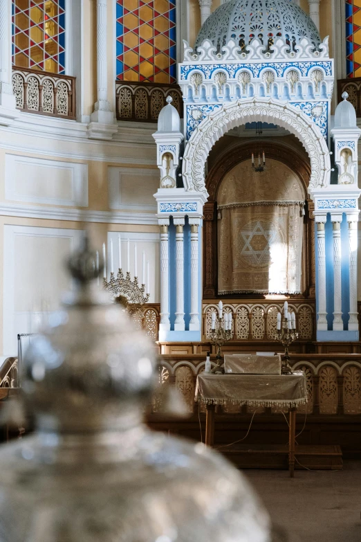 a silver vase sitting in the middle of a room, baroque, mosque synagogue interior, lush surroundings, altar, blue