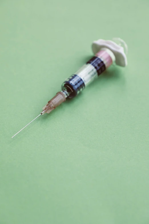 a syll sitting on top of a green surface, syringe, hyperdetailed colourful, 1999 photograph, steroid use