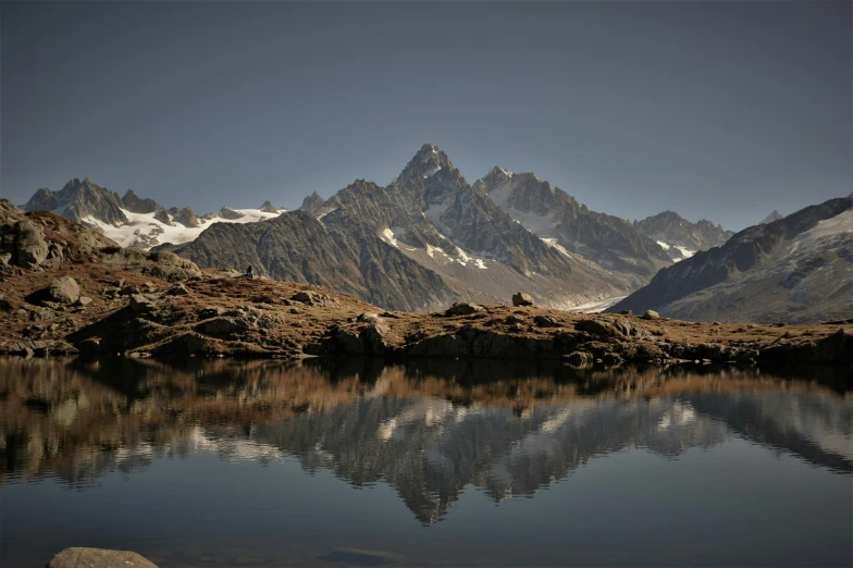 a body of water with mountains in the background, by Werner Andermatt, pexels contest winner, les nabis, peak experience ”, larapi, mirroring, brown