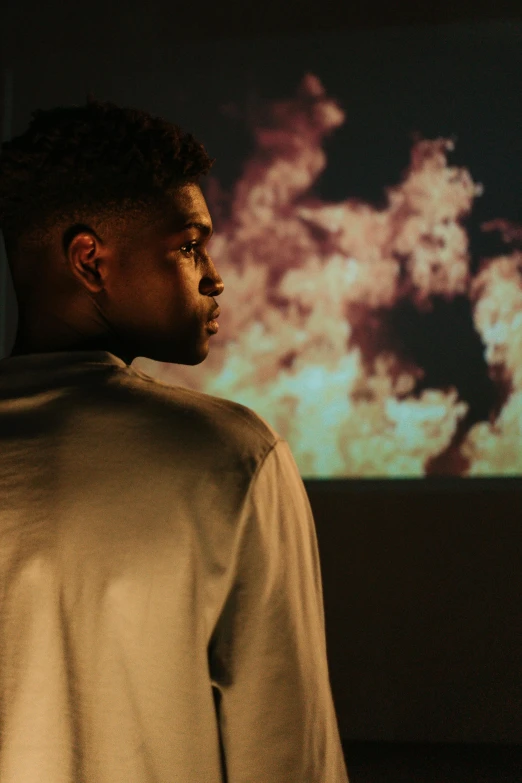 a man standing in front of a projector screen, by Frank Mason, trending on unsplash, visual art, handsome hip hop young black man, looking into the flames, off - white collection, side profile waist up portrait