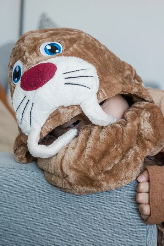a baby in a stuffed animal costume sitting on a couch, by Nina Hamnett, balaclava covering face, easy to use, otter, close up details