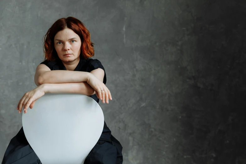 a woman sitting on top of a white chair, inspired by Sarah Lucas, renaissance, in the movie arrival, eleanor tomlinson, round-cropped, björk