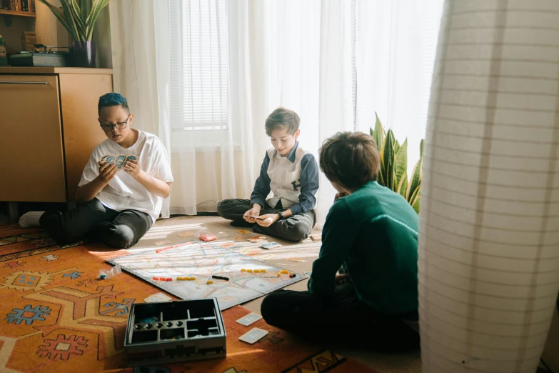 a group of people sitting on the floor playing a game, playing board games, profile image, fan favorite, kids playing
