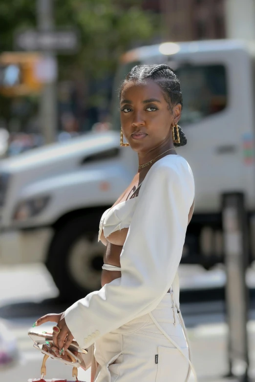 a woman walking down the street carrying a red bag, an album cover, trending on unsplash, portrait willow smith, wearing white dress, beautiful midriff, at new york fashion week