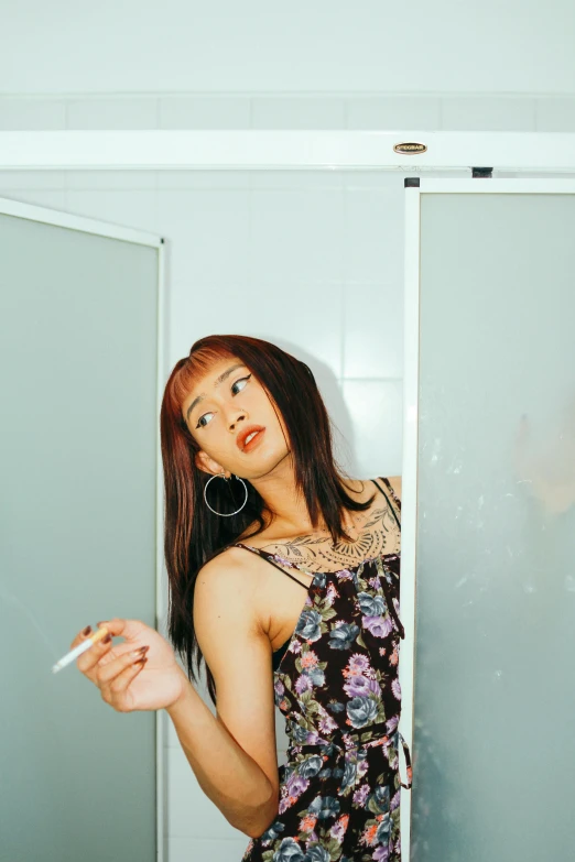 a woman in a floral dress smoking a cigarette, an album cover, by Yuki Ogura, unsplash, in bathroom, half asian, non binary model, 🚿🗝📝