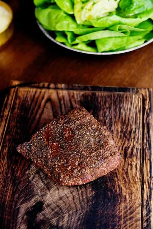 a steak sitting on top of a wooden cutting board, ethiopian, square, brown, f / 2 0