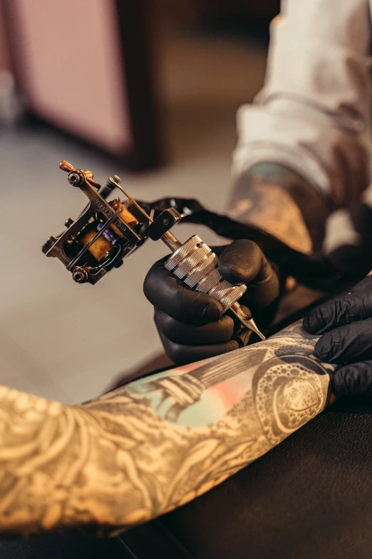 a man getting a tattoo on his arm, trending on pexels, hyperrealism, sailor jerry tattoo flash, intricate mechanical body, various colors, zen ink