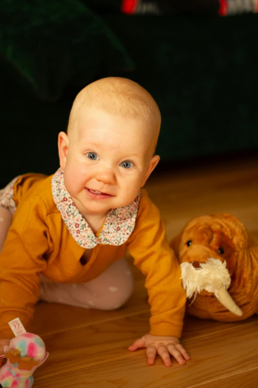 a baby crawling on the floor with a stuffed animal, inspired by Elsa Beskow, taken with sony alpha 9, portrait image, corduroy, amber