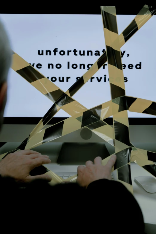 a man that is sitting in front of a computer, inspired by Arlington Nelson Lindenmuth, video art, police tape, holding a pentagram shield, close up to the screen, ignant