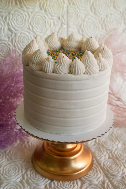 a white cake sitting on top of a gold cake stand, a stipple, delightful, full front view, multi - layer, full product shot