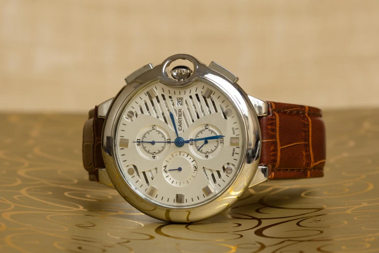 a close up of a watch on a table, an album cover, inspired by Ernest Biéler, unsplash, baroque, demur, stainless steel, tan, many exotic high end features