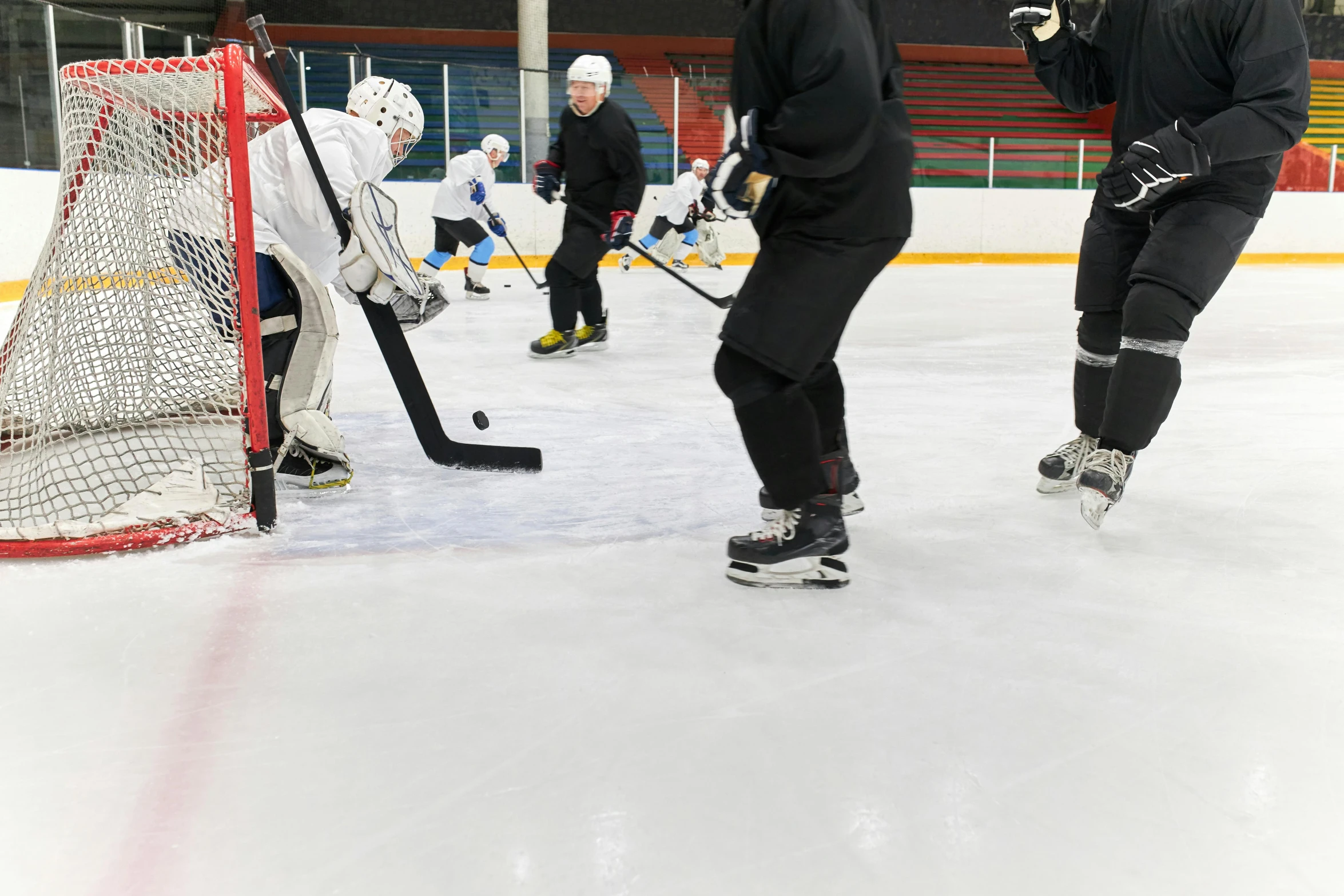 a group of people playing a game of hockey, training, full ice hockey goalie gear, thumbnail, leg and hip shot