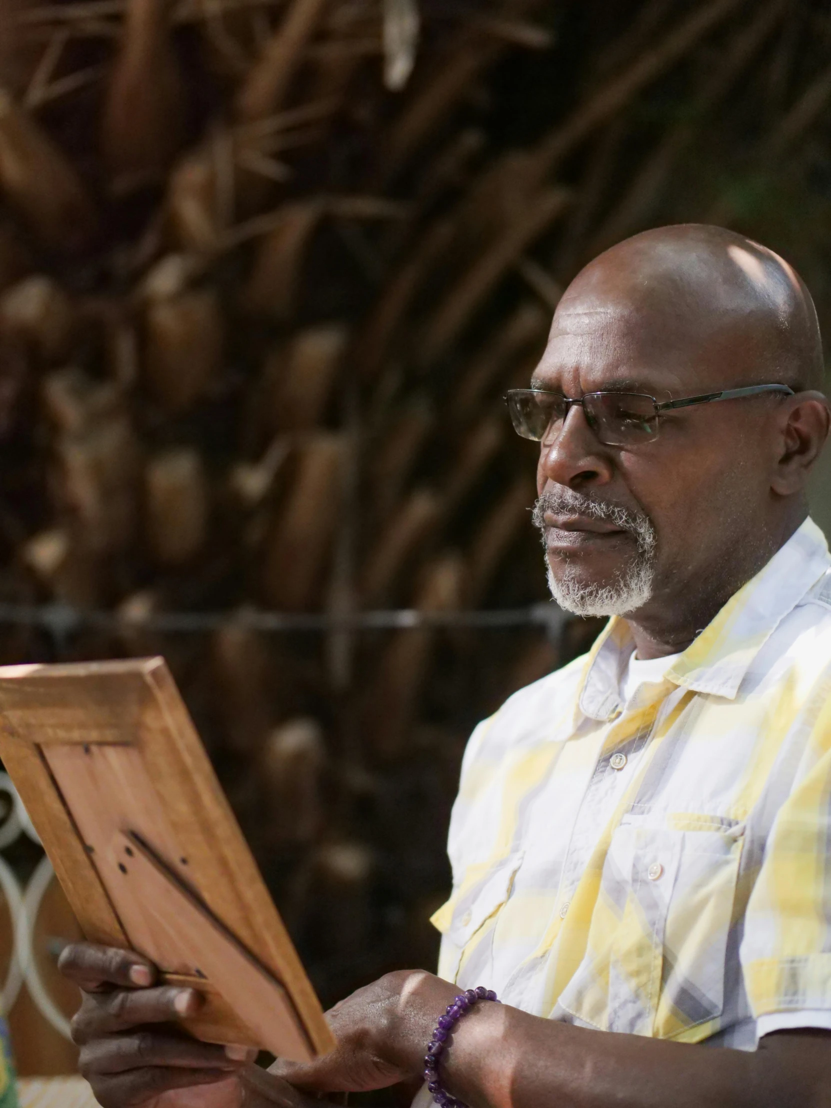 a man holding a piece of wood in his hands, a portrait, inspired by George Barret, Sr., pexels contest winner, plein air, giving a speech, lance reddick, profile image, bahamas