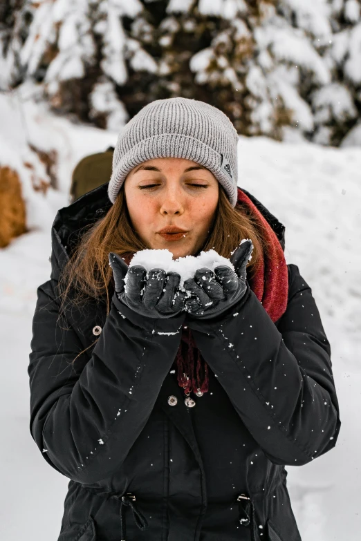 a woman blowing snow while standing in the snow, profile image, leather gloves, snacks, hiking clothes
