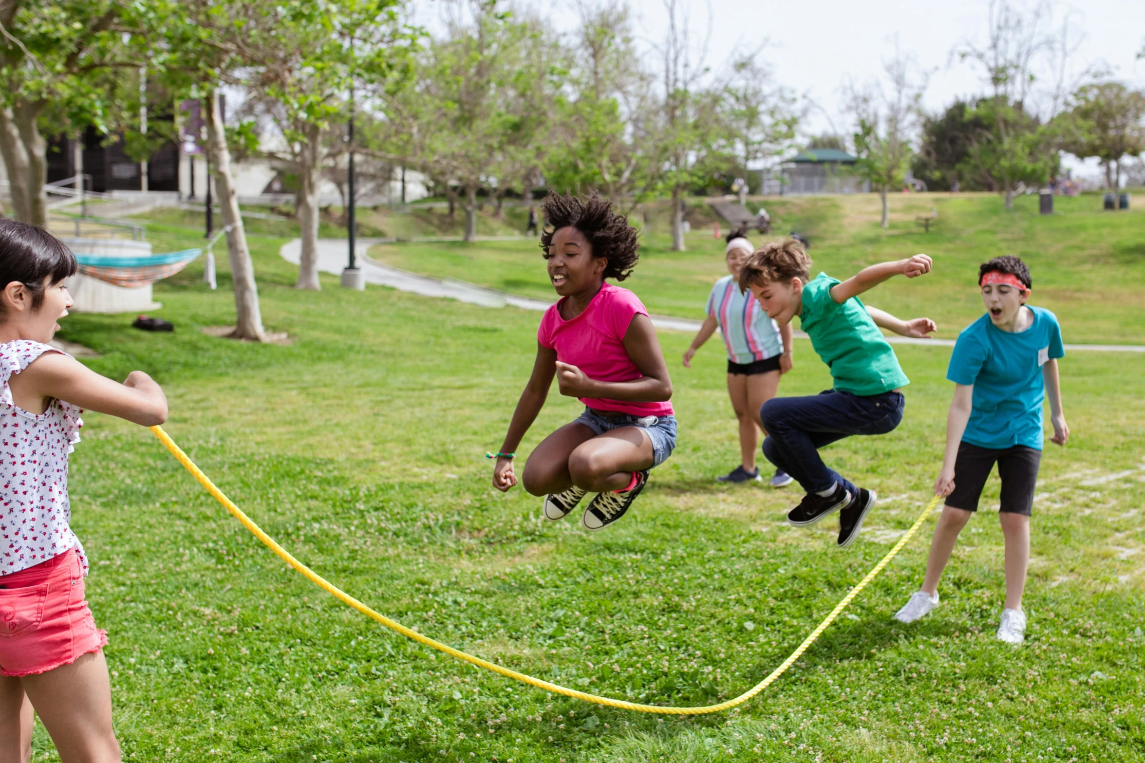 a group of children playing with a rope in a park, profile image, jumping, hypersphere, getty images proshot