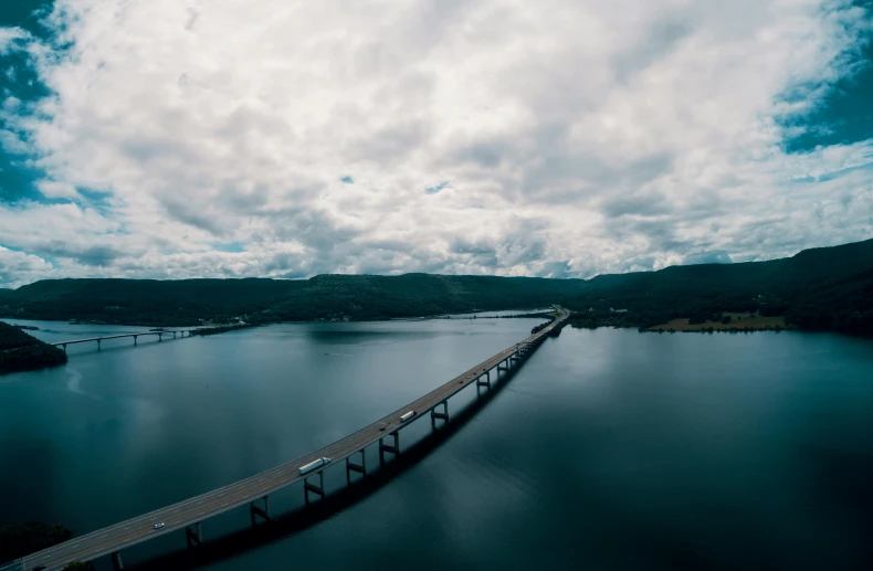 a long bridge over a large body of water, pexels contest winner, gray clouds, cornell, drone footage, thumbnail