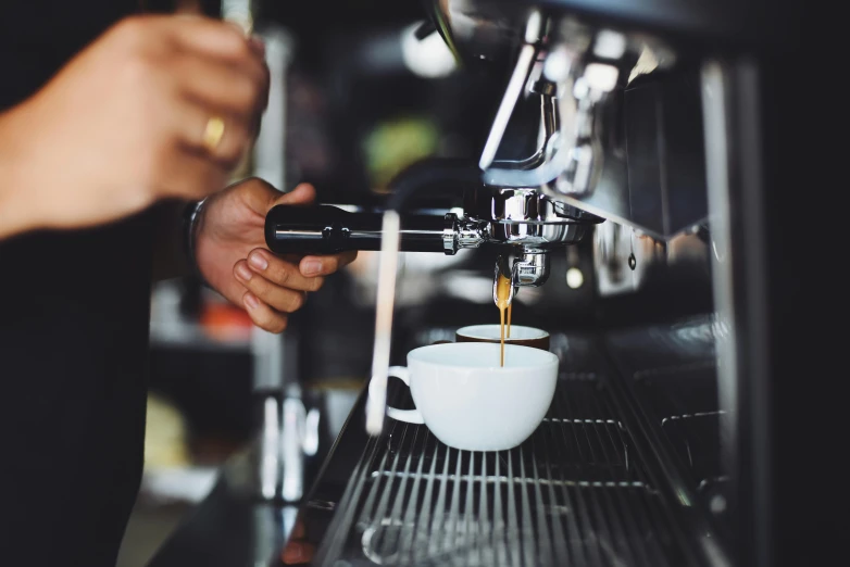 a person pouring a cup of coffee into a coffee machine, by Niko Henrichon, pexels contest winner, “ iron bark, pristine and clean, where a large, cafe