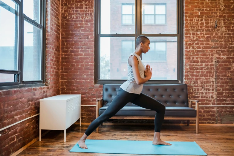 a woman doing a yoga pose in front of a window, pexels contest winner, arabesque, walking to the right, working out, alexis franklin, lower quality