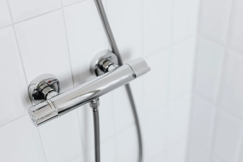 a close up of a shower head in a bathroom, holding a cane, detailed product image, with big chrome tubes, subtle detailing