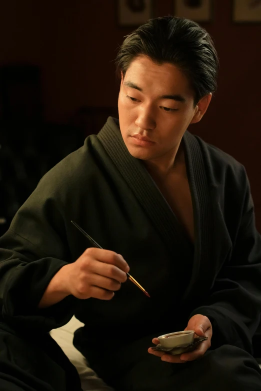 a man sitting on a bed holding a cell phone, a photorealistic painting, inspired by Kanō Tanshin, unsplash, shin hanga, wearing dark green robes, film promotional still, chopsticks, sumo wrestler