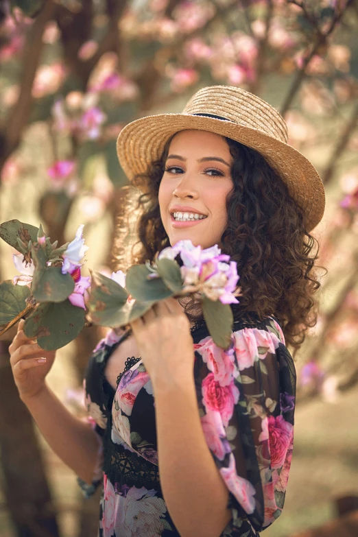 a woman in a hat holding a bunch of flowers, pexels contest winner, oona chaplin, curly haired, avatar image, flowers and trees