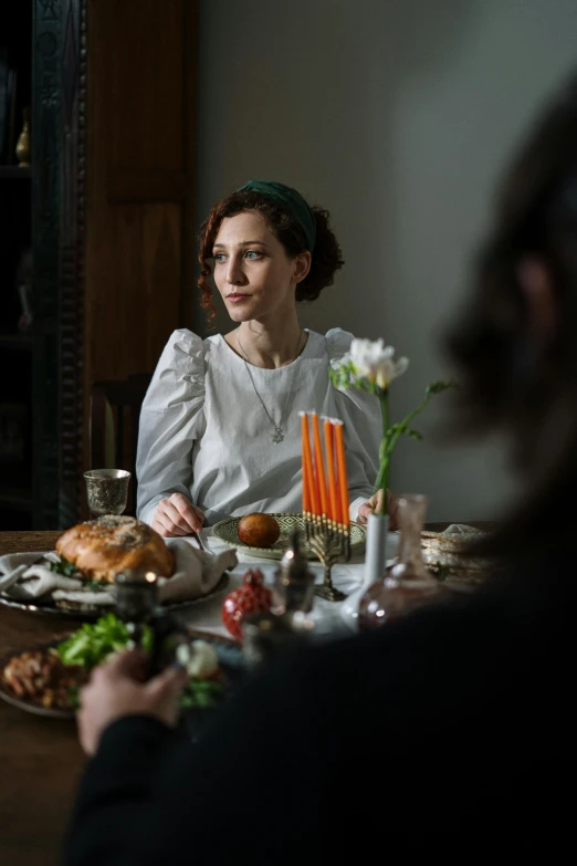 a couple of people that are sitting at a table, inspired by Hedda Sterne, renaissance, victorian thanksgiving feast, film still of gal gadot, beautiful jewish woman, shot on sony a 7 iii