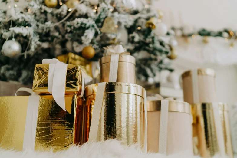 a bunch of bottles sitting next to a christmas tree, draped in silky gold, profile image, gifts, background image