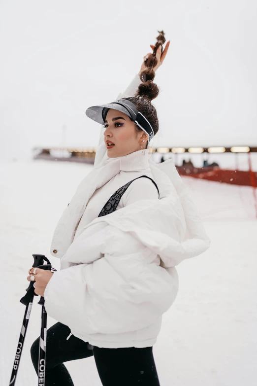 a woman riding skis on top of a snow covered slope, an album cover, inspired by Ion Andreescu, trending on pexels, white baseball cap, profile image, glam photo, icon