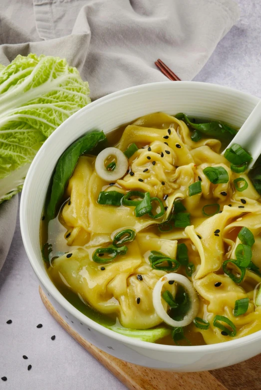 a bowl of soup sitting on top of a cutting board, inspired by Tan Ting-pho, intricate pasta waves, yellow, lei min, detailed product image