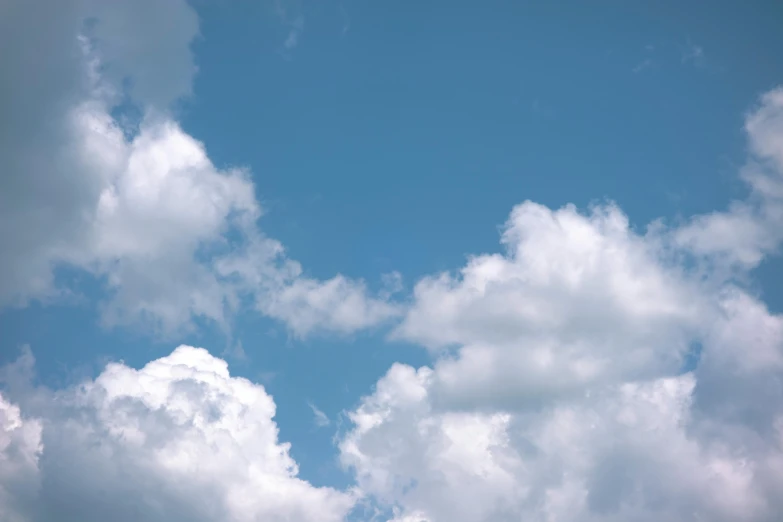 a plane flying through a cloudy blue sky, unsplash, minimalism, cumulus clouds, low angle 8k hd nature photo, video still, high resolution