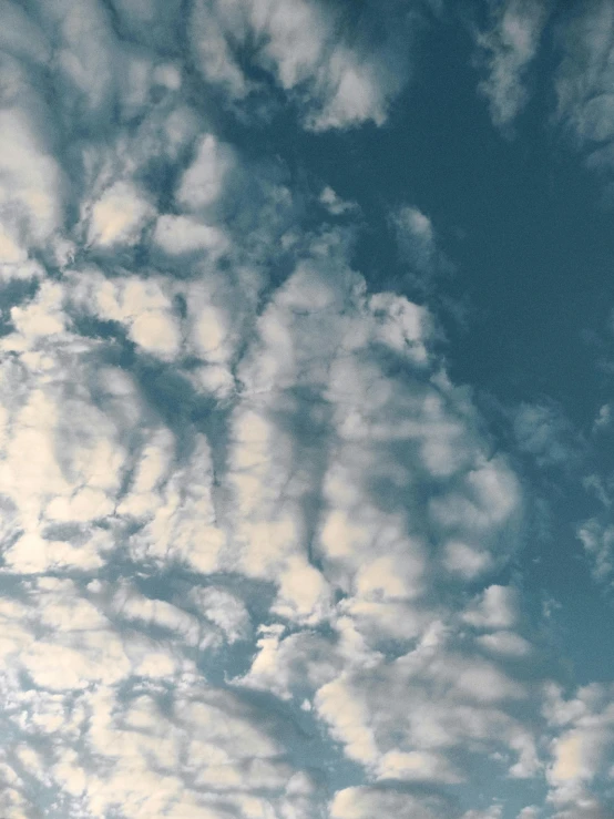 a plane flying through a cloudy blue sky, an album cover, inspired by Elsa Bleda, unsplash, romanticism, ☁🌪🌙👩🏾, layered stratocumulus clouds, # nofilter, mario clouds