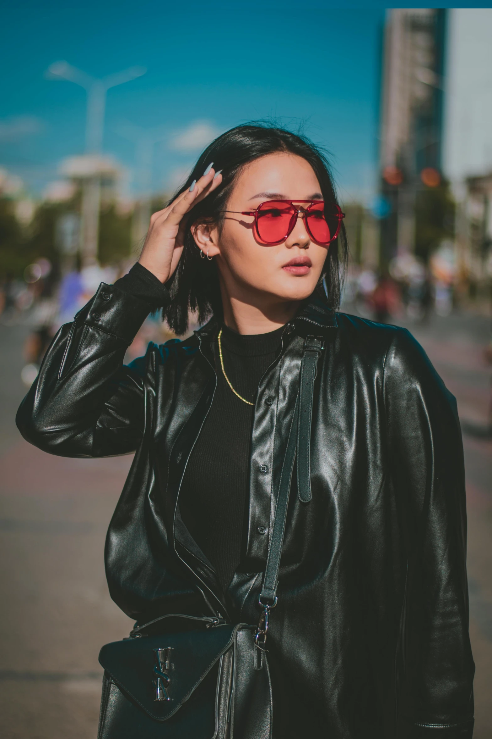 a woman wearing a black leather jacket and red sunglasses, a picture, trending on pexels, mai anh tran, rectangle, instagram post, woman in streetwear