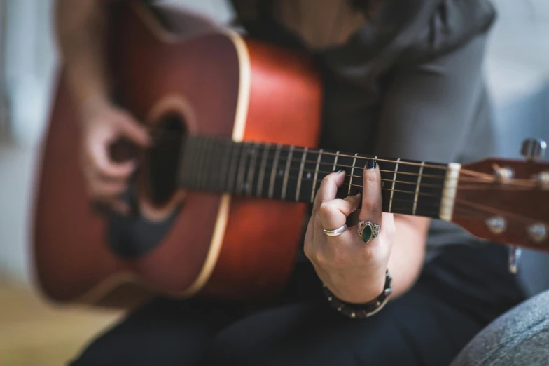 a close up of a person playing a guitar, an album cover, by Winona Nelson, trending on pexels, 15081959 21121991 01012000 4k, female gigachad, 50mm photo, linsey levendall